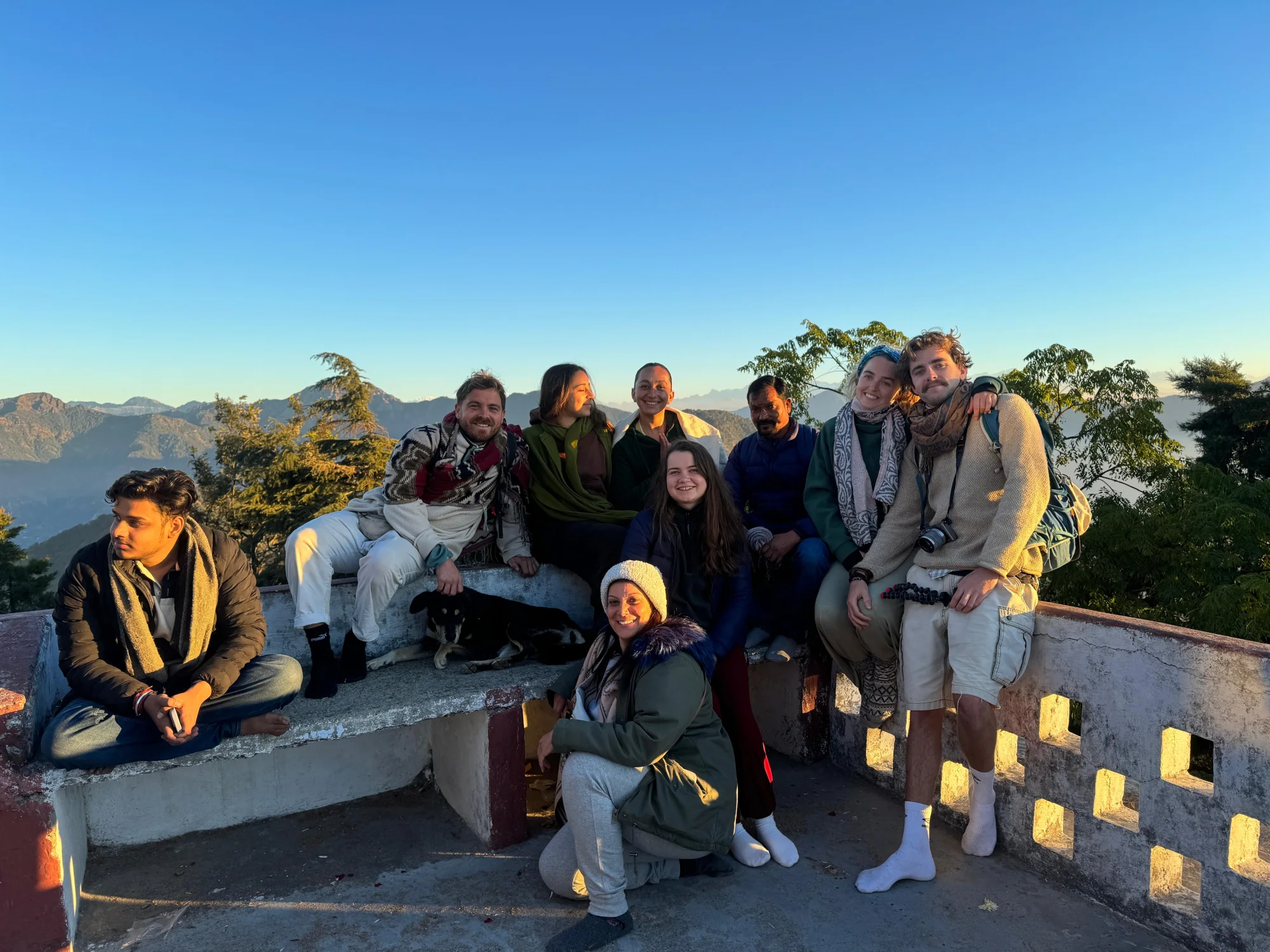 Yoga students watching the sunrise over the hills from a rooftop near Rishikesh