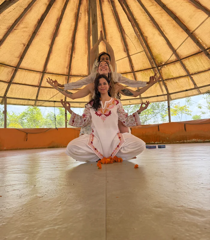 Two students in a seated partner pose in the dome yoga hall